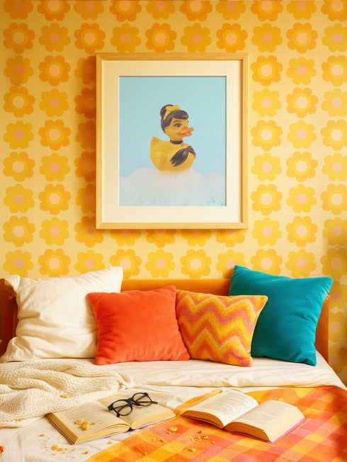 A chic rubber duck styled like Audrey Hepburn’s Holly Golightly, wearing a high bun, yellow bow, black gloves, and a sparkly choker. The duck floats in a pile of foam and is framed in white on a bubbly bathroom shelf with a red tile backdrop and soap dispenser.